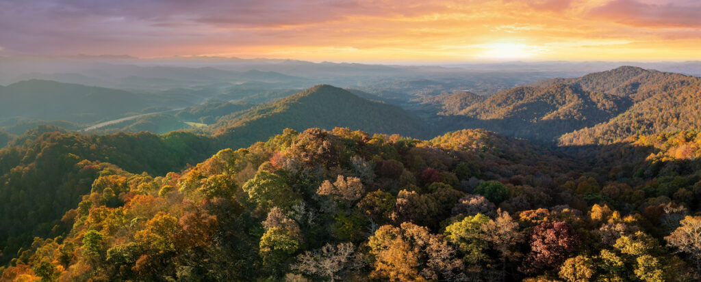 Wooded sunset hills of the Appalachian Mountains in North Carolina with lush and evergreen forest trees in the fall season. Beauty of autumnal nature.