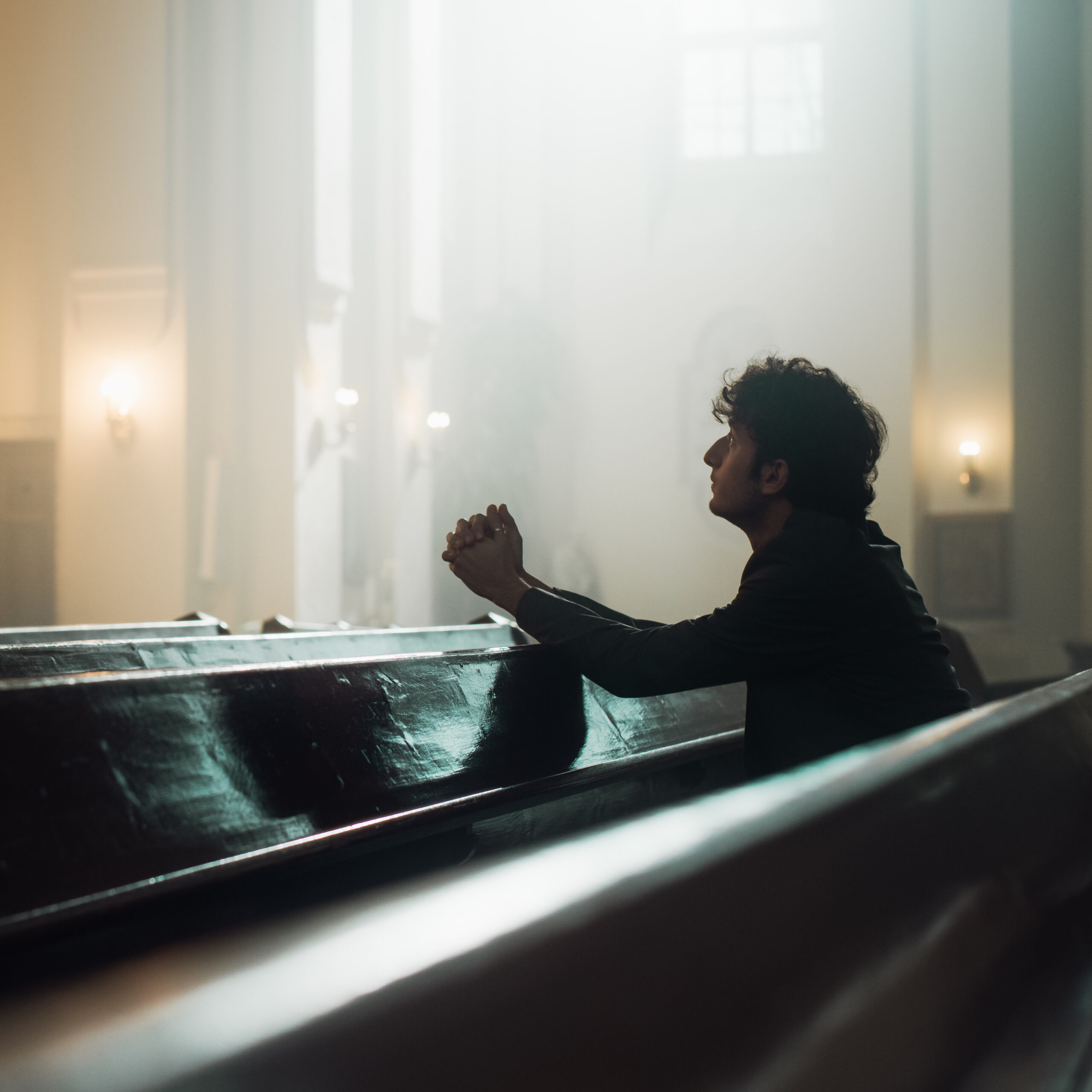 young man in church praying.