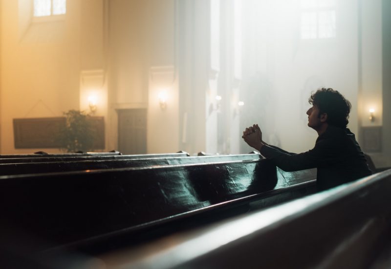 In A Grand Old Church, A Devout Christian Sits, finding Comfort in Faith. Contemplating Life, Seeking Moral Guidance. Sacred Space is Filled With Religious Atmosphere, Providing Solace To The Faithful